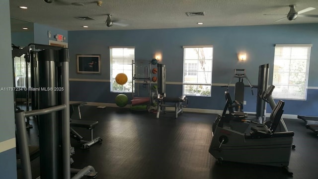 workout area with a ceiling fan, a healthy amount of sunlight, and a textured ceiling