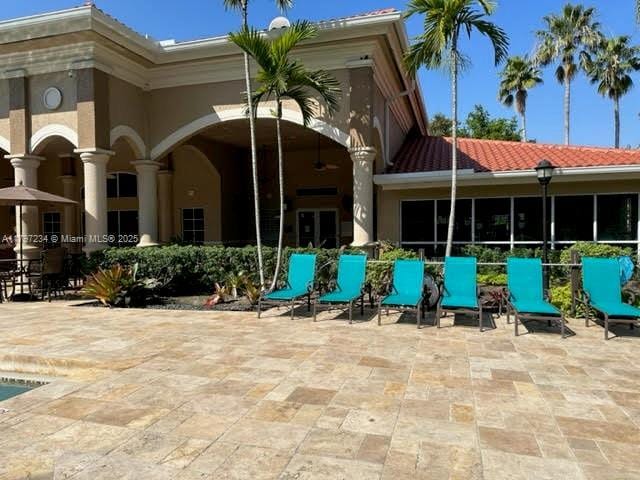 exterior space featuring a patio, a tiled roof, and stucco siding