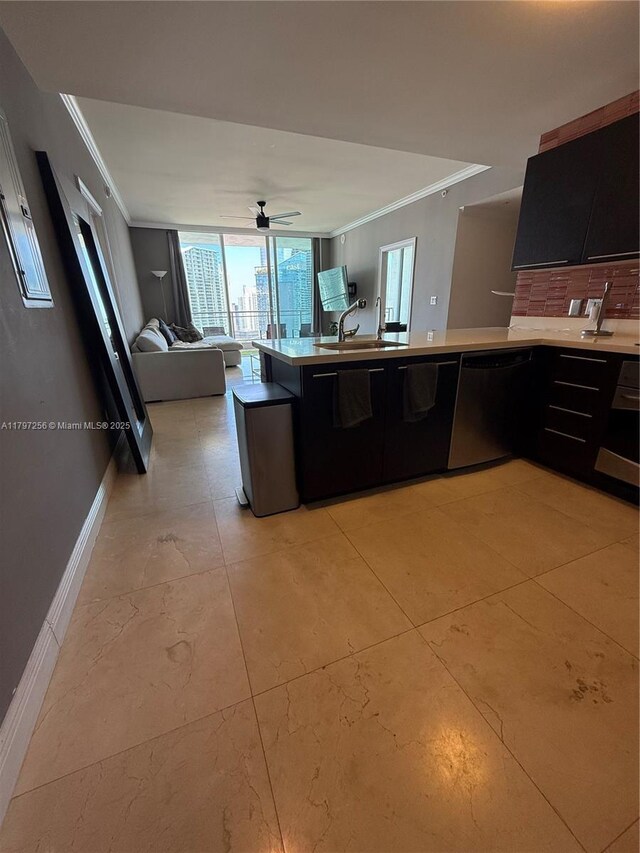 kitchen featuring crown molding, a sink, dishwasher, open floor plan, and dark cabinets