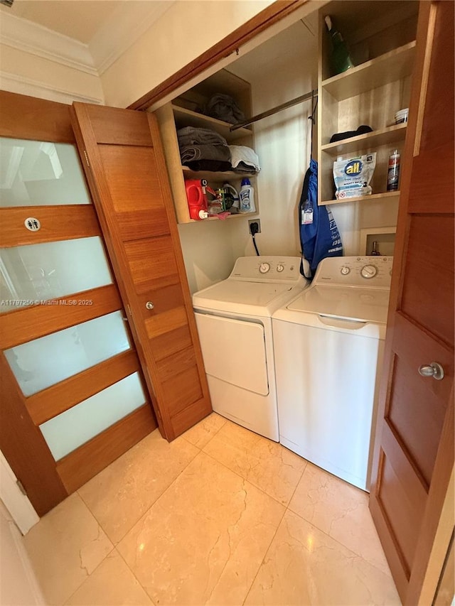 laundry area featuring washing machine and clothes dryer, crown molding, and light marble finish flooring