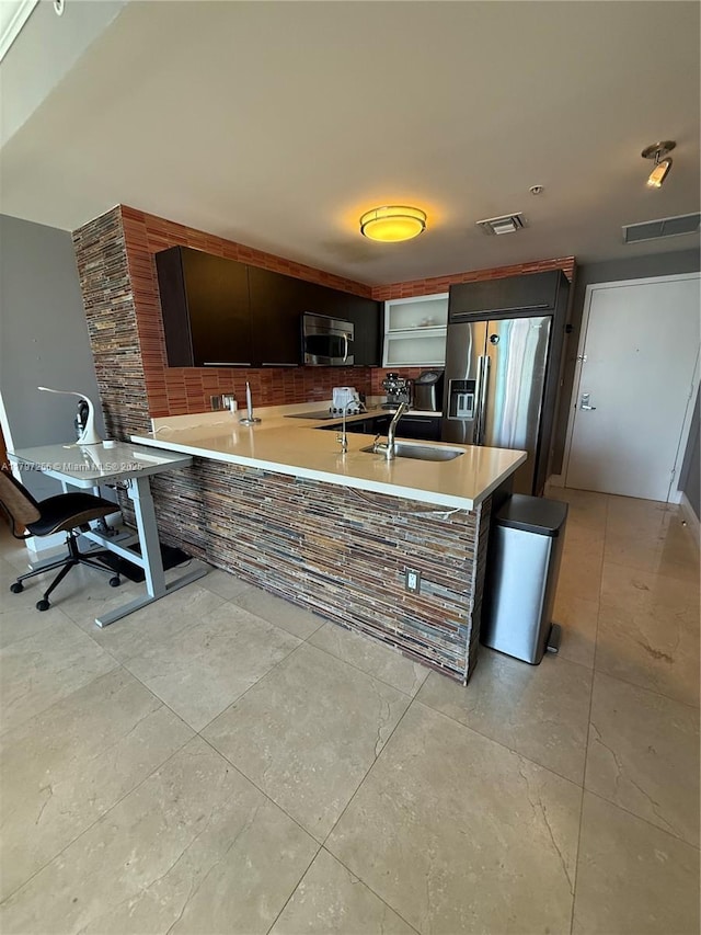 kitchen with stainless steel appliances, a sink, open shelves, a peninsula, and light countertops