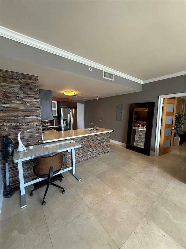 bar area featuring stainless steel fridge, a sink, baseboards, crown molding, and electric panel