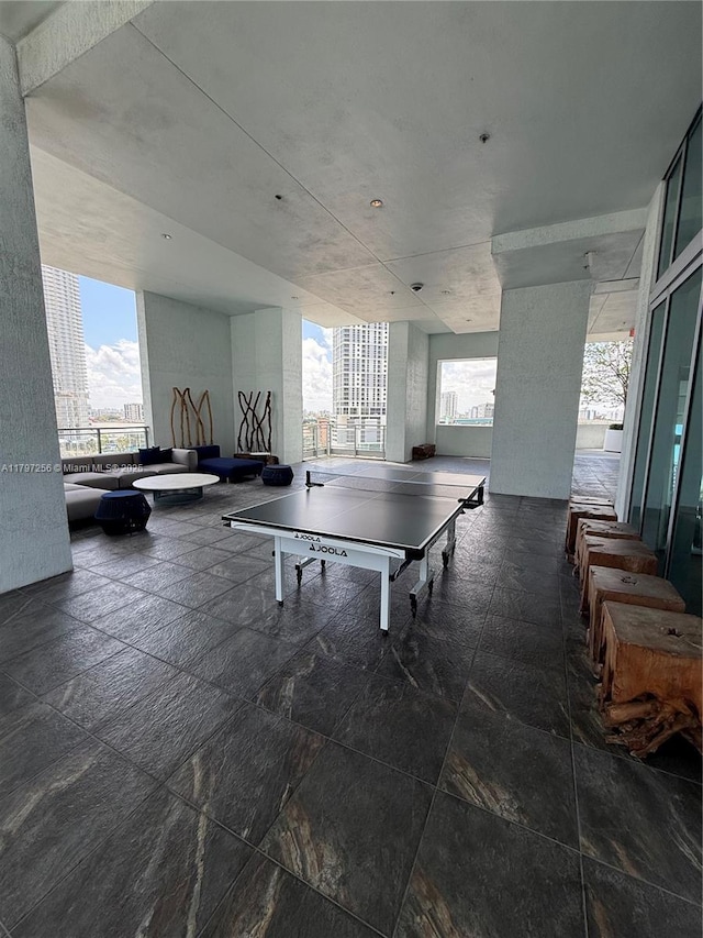 playroom featuring stone tile floors, a view of city, and a wall of windows