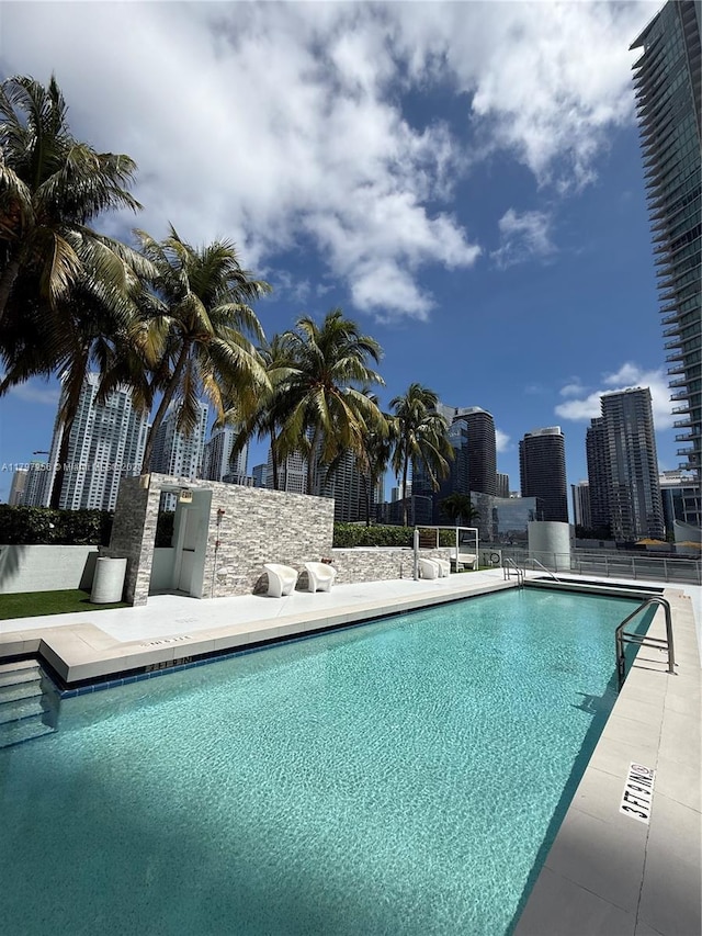 community pool featuring a skyline view and a patio area