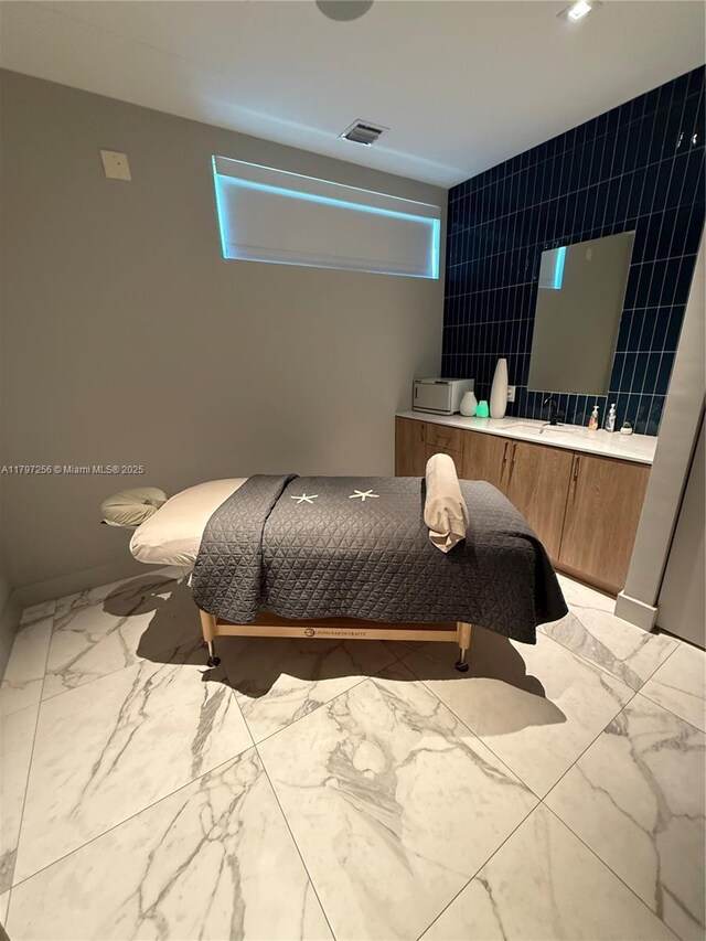 bedroom with light marble finish flooring, tile walls, and recessed lighting