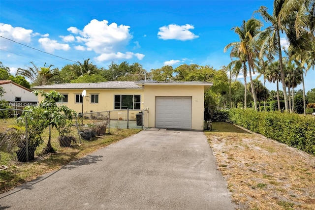 ranch-style home featuring stucco siding, aphalt driveway, an attached garage, and fence