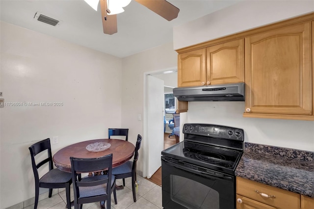 kitchen featuring under cabinet range hood, light tile patterned floors, visible vents, and electric range