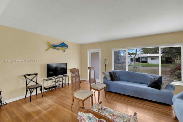 living area with baseboards and wood finished floors