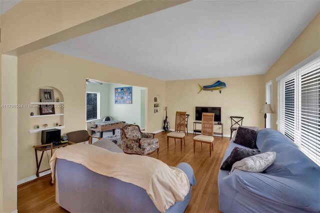 living room featuring baseboards, a healthy amount of sunlight, and wood finished floors