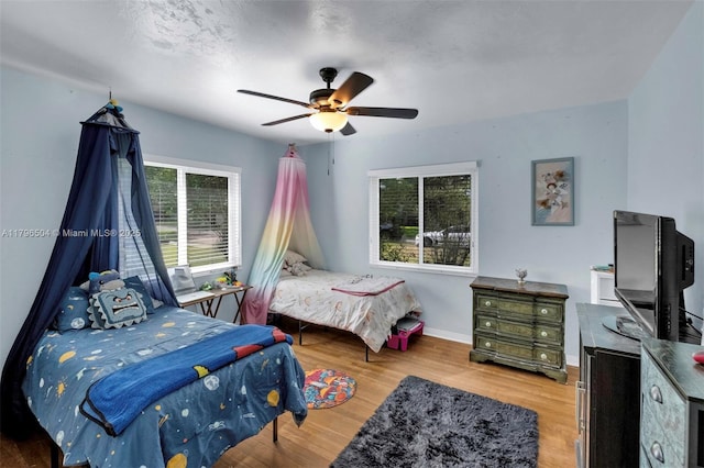 bedroom featuring baseboards, ceiling fan, and wood finished floors