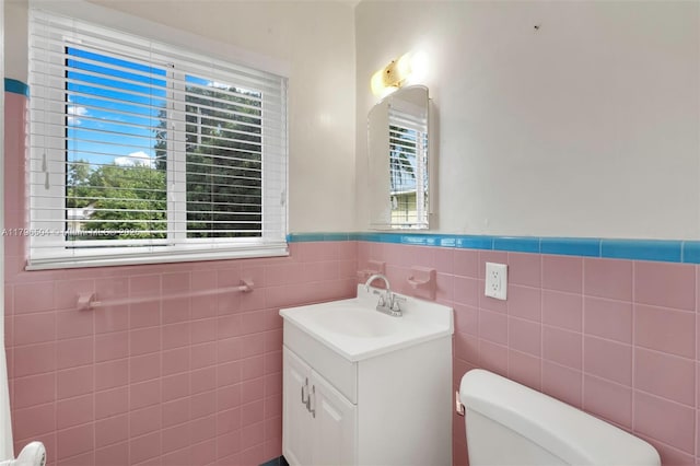 bathroom featuring wainscoting, toilet, and plenty of natural light