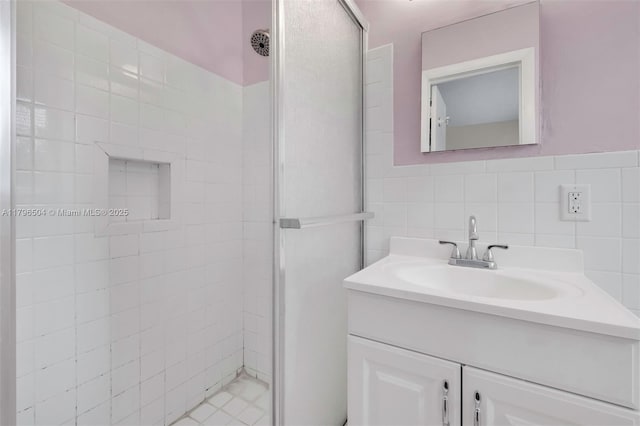 bathroom featuring tile walls, vanity, and a shower stall