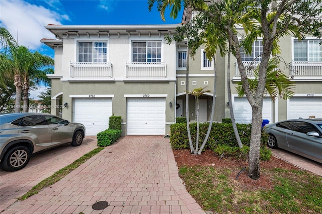 multi unit property featuring stucco siding, driveway, and a garage