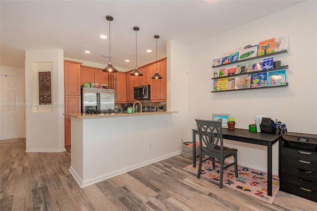 kitchen with stainless steel appliances, light wood-style flooring, recessed lighting, and decorative light fixtures