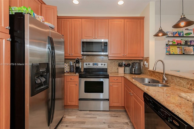 kitchen featuring a sink, light wood-type flooring, appliances with stainless steel finishes, light stone counters, and recessed lighting