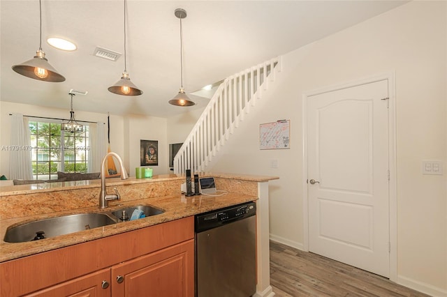 kitchen with a sink, dishwasher, light wood-style flooring, hanging light fixtures, and baseboards