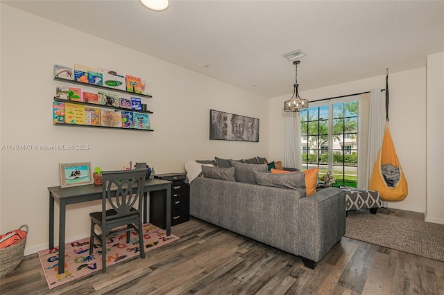 living area featuring baseboards, an inviting chandelier, visible vents, and wood finished floors
