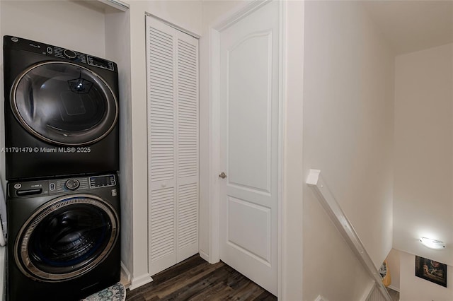 washroom with laundry area, stacked washer / drying machine, and dark wood-type flooring