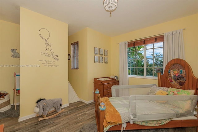 bedroom with baseboards and wood finished floors