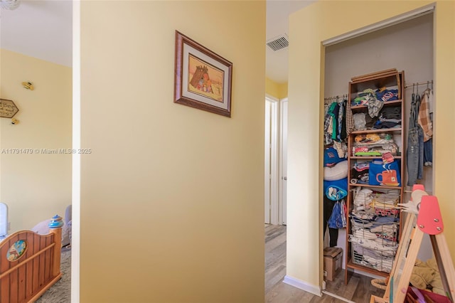 corridor featuring visible vents and wood finished floors