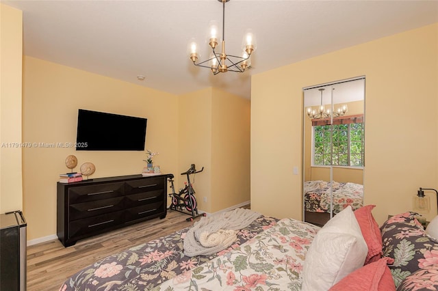 bedroom featuring light wood finished floors and a chandelier