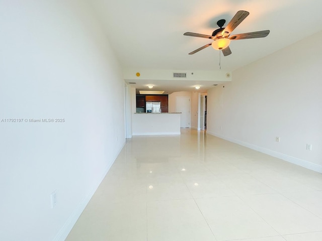 empty room with a ceiling fan, baseboards, light tile patterned floors, and visible vents