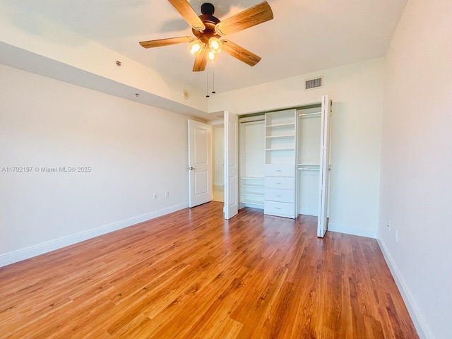unfurnished bedroom featuring a closet, light wood-type flooring, visible vents, baseboards, and ceiling fan