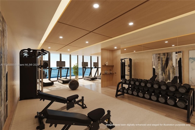 exercise room with a wall of windows, recessed lighting, and wood finished floors