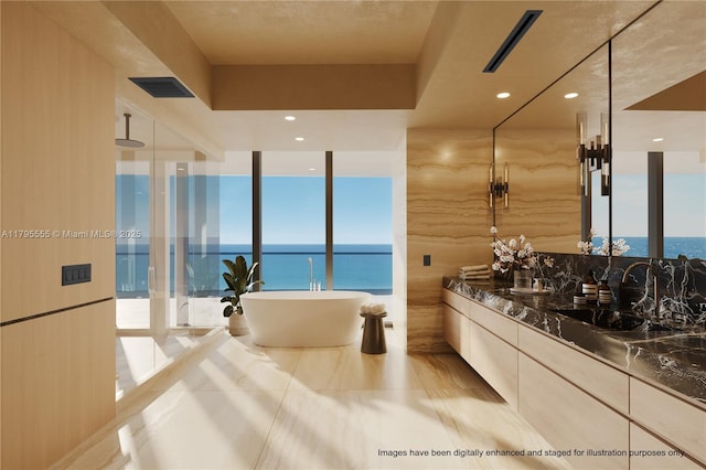 full bathroom with a wall of windows, a soaking tub, a wealth of natural light, walk in shower, and vanity
