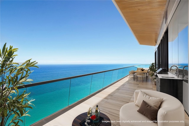 balcony featuring a water view and a sink