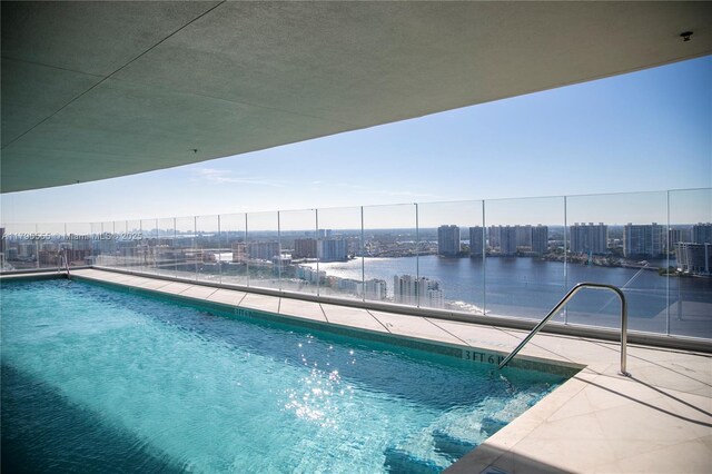 pool with a city view, a water view, and fence