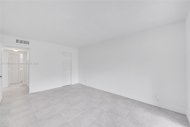 unfurnished room featuring light tile patterned flooring and visible vents