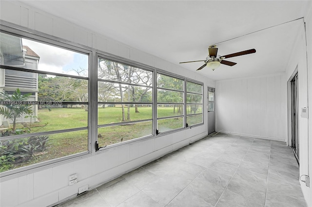 unfurnished sunroom featuring ceiling fan