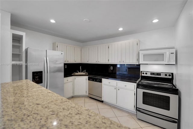 kitchen featuring tasteful backsplash, recessed lighting, light tile patterned floors, white cabinets, and appliances with stainless steel finishes