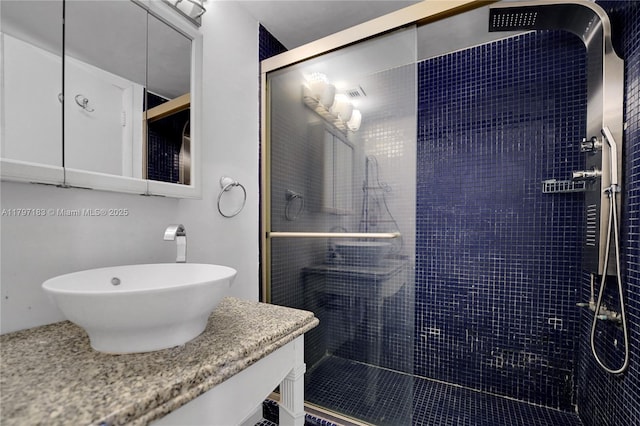 bathroom with vanity and a tile shower