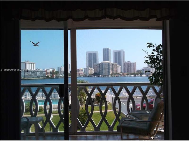 balcony with a water view and a view of city