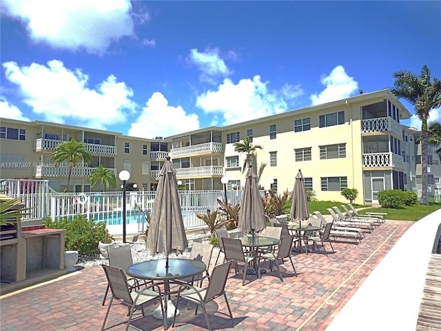 view of patio featuring fence and a community pool