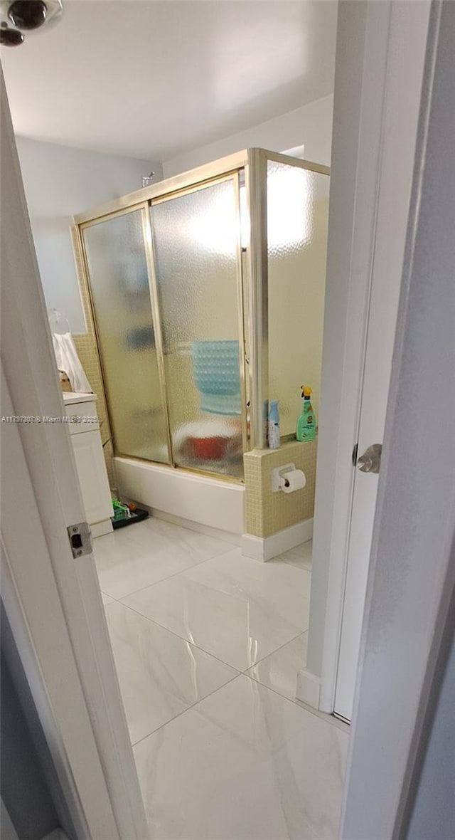 bathroom featuring bath / shower combo with glass door and marble finish floor