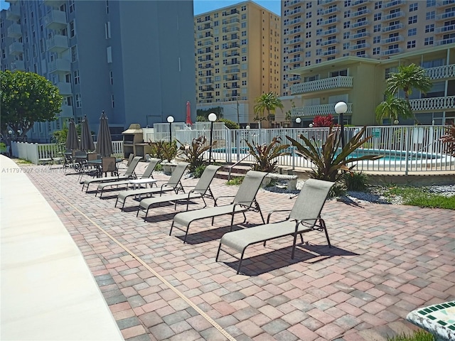 view of community featuring fence, a patio area, and a pool