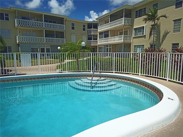 450 Golden Isles Dr Unit 2H, Hallandale Beach, FL 33009 - pool featuring fence