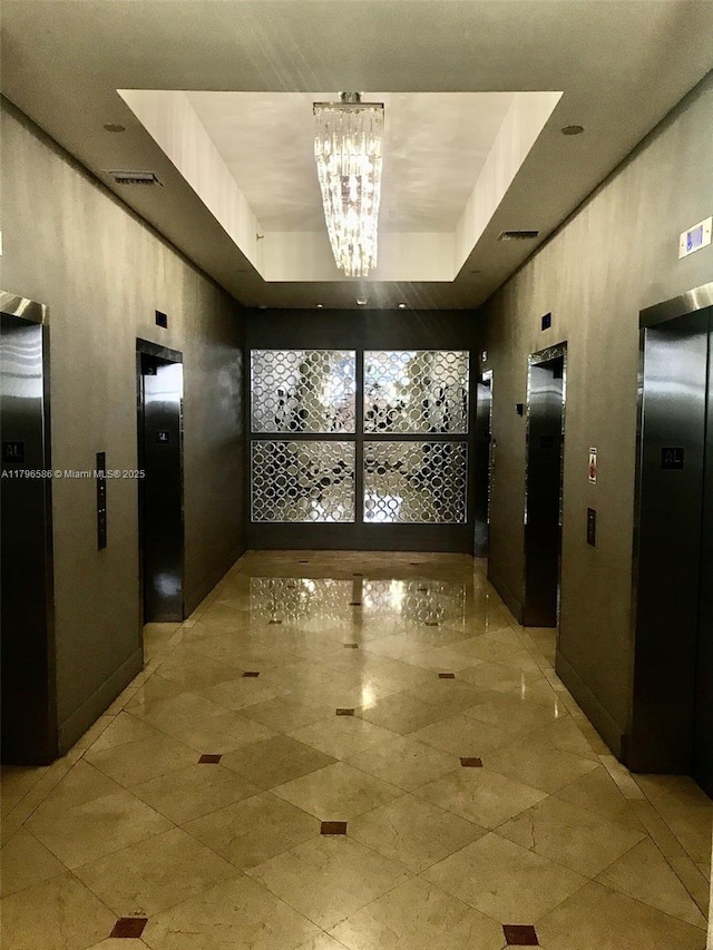 100 Lincoln Rd Unit 1209, Miami Beach, FL 33139 - corridor featuring an inviting chandelier, a raised ceiling, elevator, and visible vents