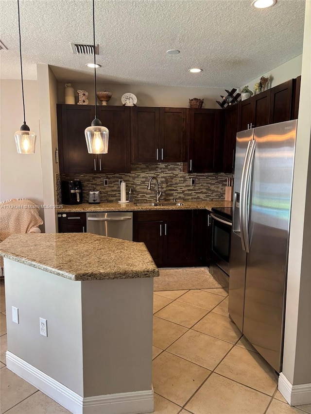 kitchen featuring visible vents, appliances with stainless steel finishes, a sink, and decorative backsplash