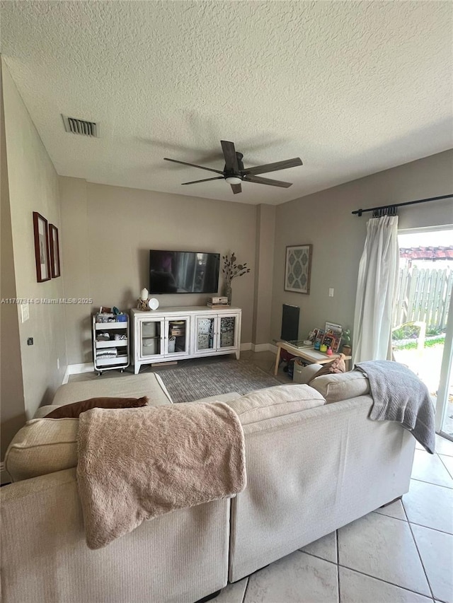 tiled living area with a ceiling fan, visible vents, and a textured ceiling