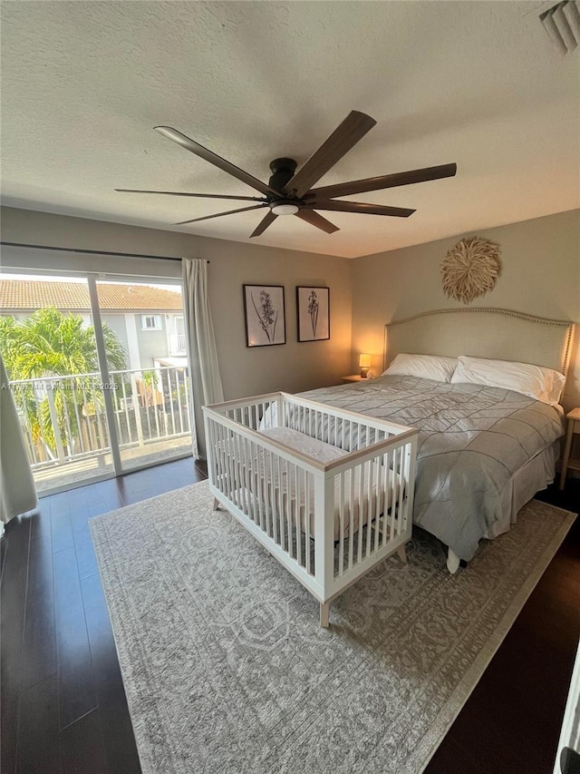 bedroom featuring wood finished floors, a textured ceiling, visible vents, a ceiling fan, and access to outside