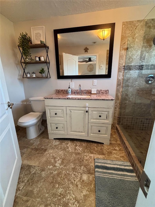 full bathroom with a stall shower, vanity, and toilet