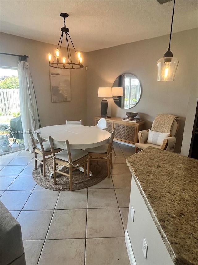 dining space featuring light tile patterned floors, a wealth of natural light, and a textured ceiling