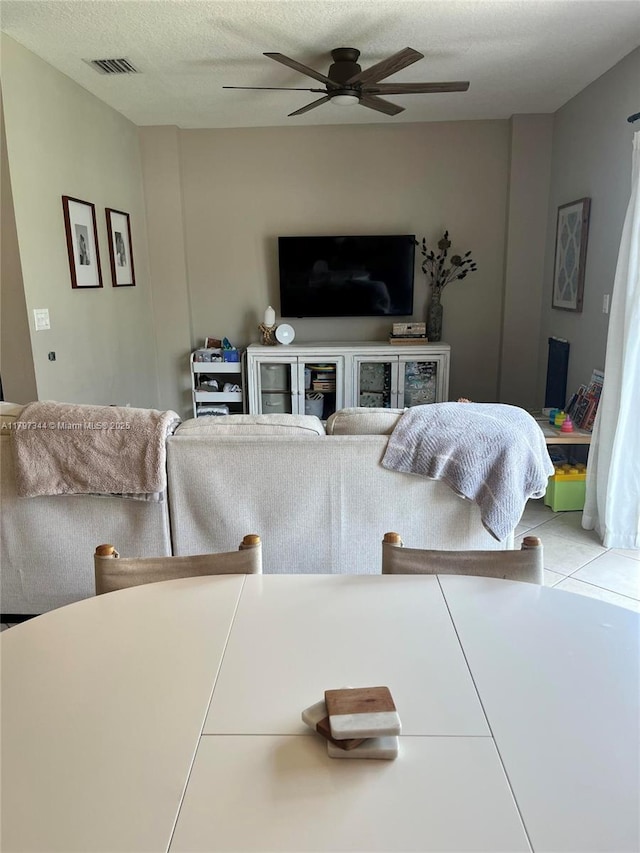living room with a ceiling fan and visible vents