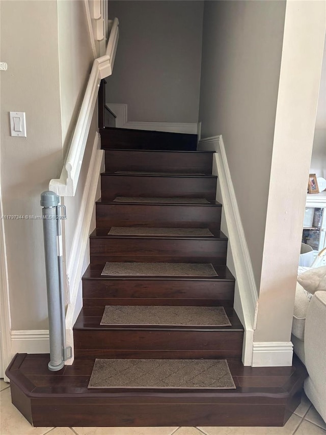 staircase featuring baseboards