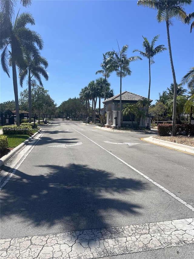 view of road featuring a gated entry and curbs