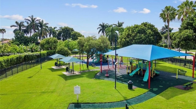 community jungle gym with a lawn and fence